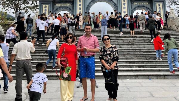 Bà Hoàng Thị Phong Thu chụp ảnh kỷ niệm với du khách Nga trước chùa Linh Ứng Đà Lạt - Sputnik Việt Nam