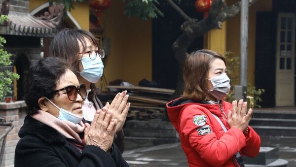 Người dân lễ chùa đeo khẩu trang phòng, chống dịch viêm đường hô hấp do Virus corona.  - Sputnik Việt Nam
