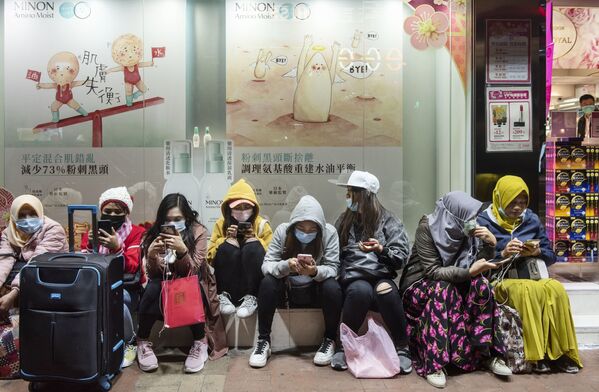 Phụ nữ đeo mặt nạ khẩu trang trên đường phố Hồng Kông - Sputnik Việt Nam