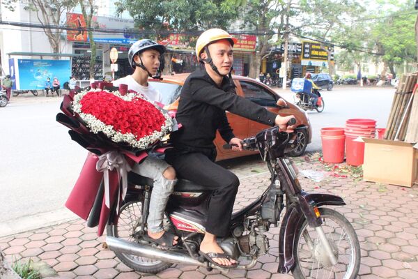 Nhân viên cửa hàng hàng hoa One flower (đường Phan Đình Phùng, thành phố Hà Tĩnh) giao hoa đến cho khách hàng theo dịch vụ điện hoa online - Sputnik Việt Nam