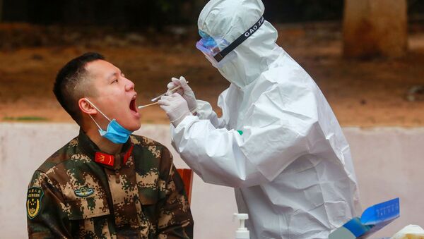 Một nhân viên y tế lấy mẫu từ cảnh sát để kiểm tra coronavirus sau khi trở về từ kỳ nghỉ, Trung Quốc - Sputnik Việt Nam