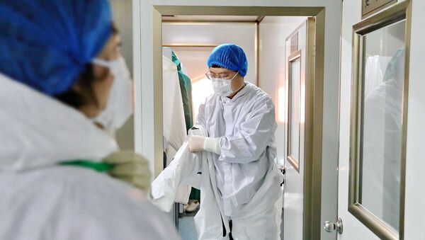 Nhân viên phòng thí nghiệm mặc một bộ đồ bảo vệ trước khi kiểm tra các mẫu tại Trung tâm phòng chống và kiểm soát dịch bệnh Qinhuangdao ở Hà Bắc, Trung Quốc - Sputnik Việt Nam