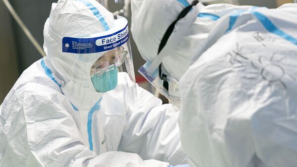 Nhân viên y tế mặc quần áo bảo hộ cho bệnh nhân bị coronavirus tại bệnh viện ở Đại học Vũ Hán - Sputnik Việt Nam
