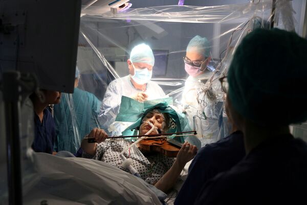 Nữ bệnh nhân bệnh viện Anh Dagmar Turner chơi violin trong ca phẫu thuật cắt bỏ khối u não, London - Sputnik Việt Nam