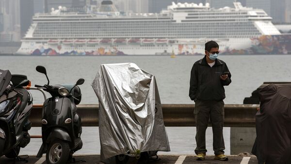 Một cư dân địa phương trên nền của tàu du lịch World Dream ở cảng Hồng Kông. - Sputnik Việt Nam