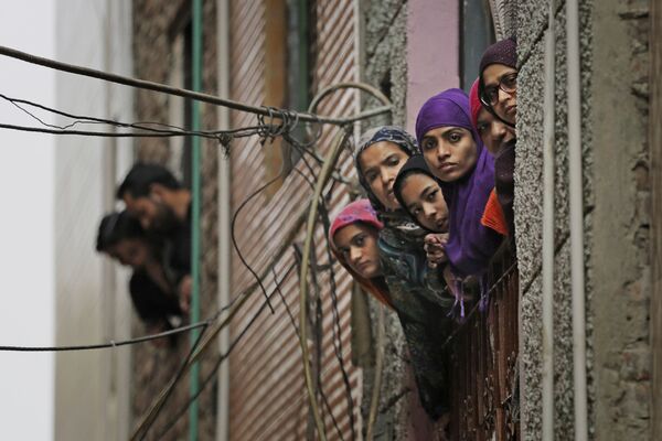 Phụ nữ Hồi giáo Ấn Độ nhìn ra cửa sổ khi nhân viên an ninh tuần tra trên đường phố New Delhi - Sputnik Việt Nam