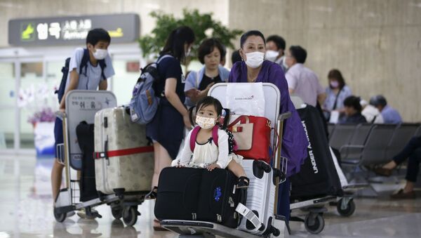 Пассажиры в защитных респираторных масках в аэропорту Гимпо в Сеуле  - Sputnik Việt Nam