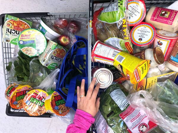 Khách hàng với chiếc xe đẩy chất đầy ắp thực phẩm ở siêu thị Canada - Sputnik Việt Nam