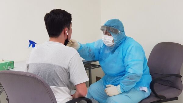 Nhân viên y tế của Trung tâm Kiểm dịch y tế quốc tế kiểm tra sức khỏe của hành khách nhập cảnh tại sân bay Tân Sơn Nhất Thành phố Hồ Chí Minh.  - Sputnik Việt Nam