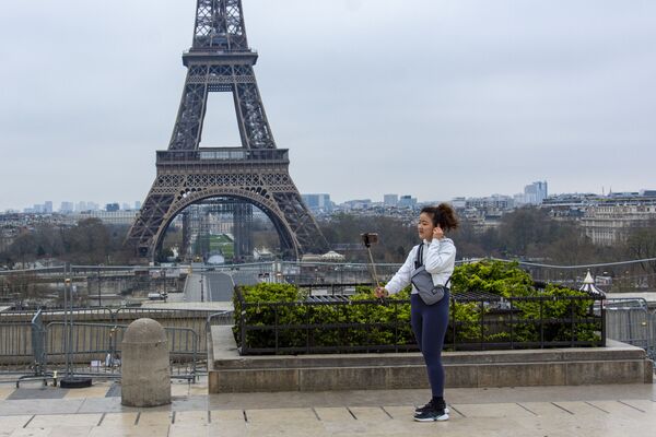 Nữ du khách chụp ảnh trên quảng trường Trocadero vắng người bên tháp Eiffel, Paris - Sputnik Việt Nam