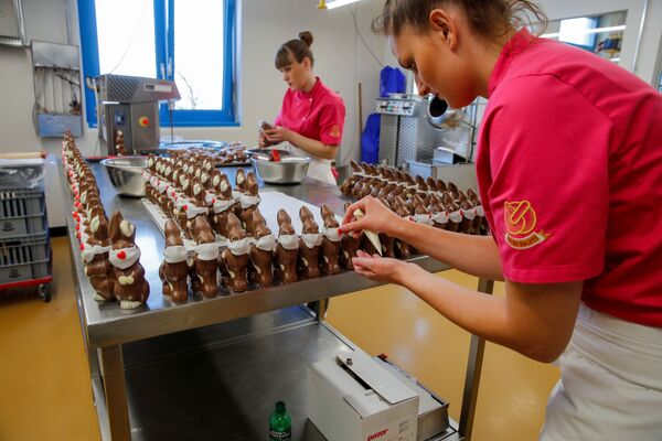 Công nhân làm sô cô la thỏ Phục sinh đeo khẩu trang tại tiệm bánh Baeckerei Bohnenblust ở Bern, Thụy Sĩ - Sputnik Việt Nam