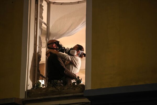 Cặp đôi yêu nhau đeo mặt nạ phòng hộ bên cửa sổ ngôi nhà ở Nice, Pháp
 - Sputnik Việt Nam