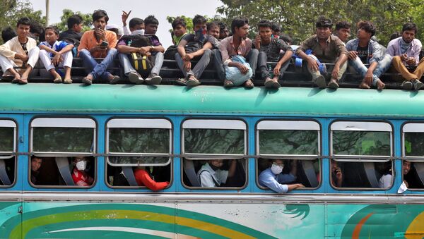 Người dân trên một chiếc xe buýt đông đúc trên đường về nhà do lệnh cách ly, tại Calcutta - Sputnik Việt Nam