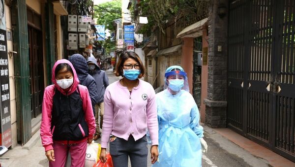 Đúng 10h nhân viên y tế bệnh viện Bạch Mai hướng dẫn các bệnh nhân ra xe, di chuyển vào bệnh viện. - Sputnik Việt Nam