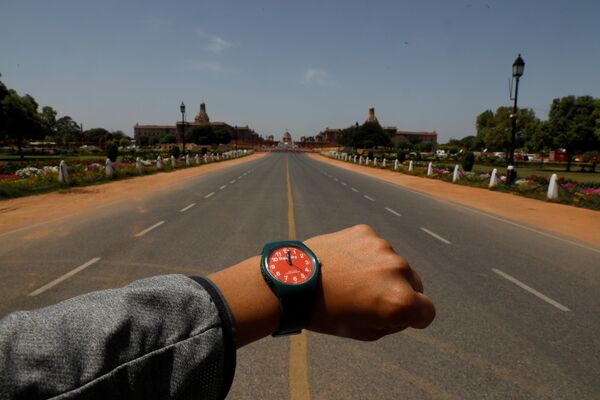 Đồng hồ đeo tay chỉ 12 giờ trưa trên nền Đại lộ Rajpath vắng người ở New Delhi trong đại dịch coronavirus - Sputnik Việt Nam