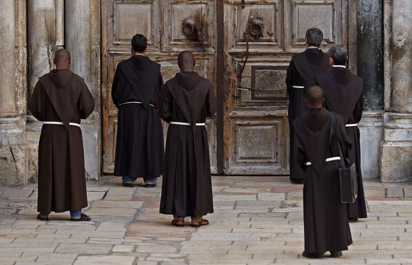 Các tu sĩ dòng Phanxicô trong buổi cầu nguyện trước cánh cửa nhà thờ đóng kín  - Sputnik Việt Nam