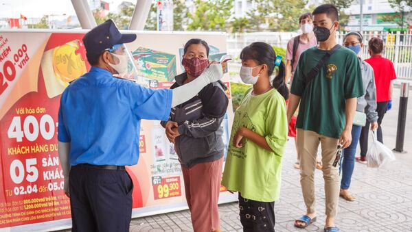 Nhân viên bảo vệ đo nhiệt độ khách hàng tại lối vào một siêu thị ở thành phố nghỉ mát Nha Trang, Việt Nam - Sputnik Việt Nam