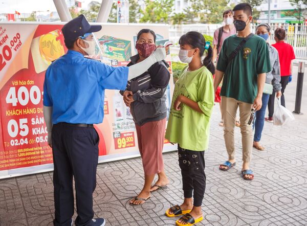 Nhân viên bảo vệ đo nhiệt độ khách hàng tại lối vào một siêu thị ở thành phố nghỉ mát Nha Trang, Việt Nam - Sputnik Việt Nam