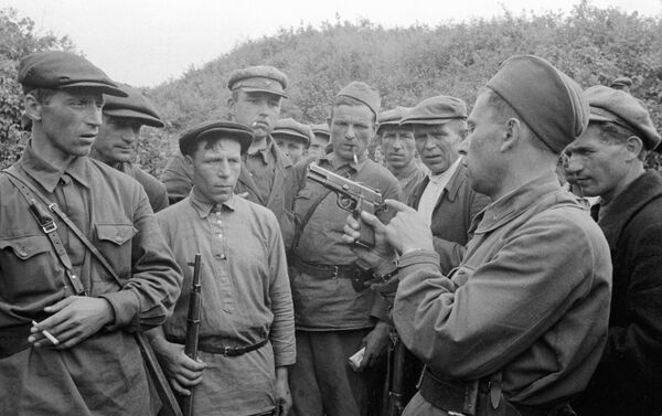 Chỉ huy của đội du kích giải thích cho những người lính cách sử dụng vũ khí, vùng Smolensk - Sputnik Việt Nam