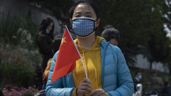 Cô gái trong mặt nạ y tế với một lá cờ quốc gia. - Sputnik Việt Nam