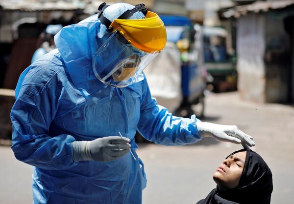 Bác sĩ mặc bộ đồ bảo vệ đang kiểm tra một cô gái bị nhiễm coronavirus ở Ahmedabad, Ấn Độ - Sputnik Việt Nam