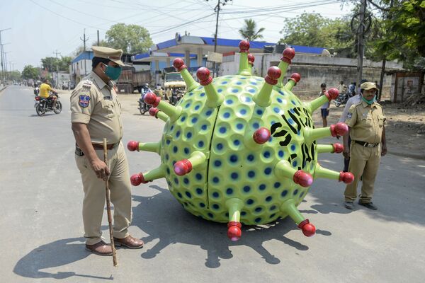 Các sĩ quan cảnh sát Ấn Độ bên cạnh một chiếc xe hơi được làm dưới hình dạng coronavirus của nhà phát minh Sudhakar Yadava - Sputnik Việt Nam