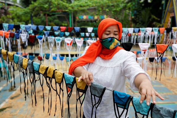 Một người phụ nữ đeo khẩu trang trong khi sản xuất khẩu trang ở Tangerang tại ngoại ô Jakarta, Indonesia - Sputnik Việt Nam