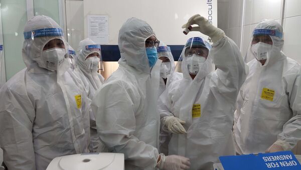 Y bác sỹ Trung tâm Kiểm soát bệnh tật Cao Bằng đang xét nghiệm mẫu máu của bệnh nhân. - Sputnik Việt Nam