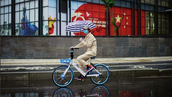 Một người phụ nữ đi xe đạp ở Vũ Hán, tỉnh Hồ Bắc. Ngày 10 tháng 4 năm 2020 - Sputnik Việt Nam