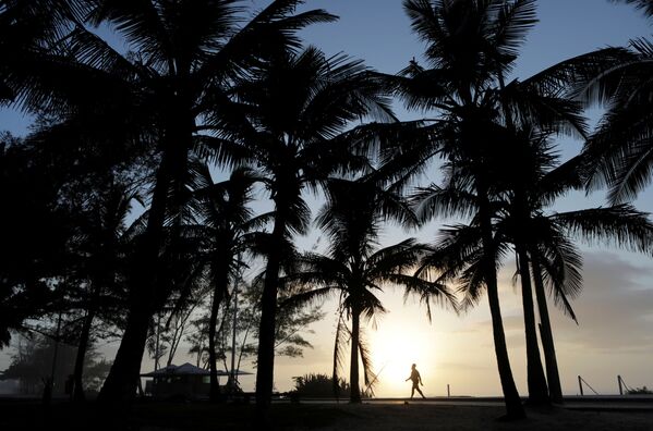 Người đàn ông đi dạo trong hoàng hôn trên bãi biển ở Rio de Janeiro, Brazil - Sputnik Việt Nam