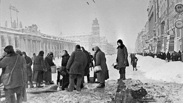Cư dân thành phố Leningrad bị bao vây lấy nước từ một lỗ trên đường nhựa xuất hiện sau vụ pháo kích - Sputnik Việt Nam