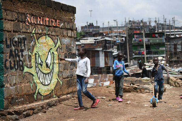 Thanh thiếu niên đứng gần tranh vẽ graffiti cảnh báo mọi người về nguy cơ COVID-19 tại khu ổ chuột Nairobi, Kenya - Sputnik Việt Nam