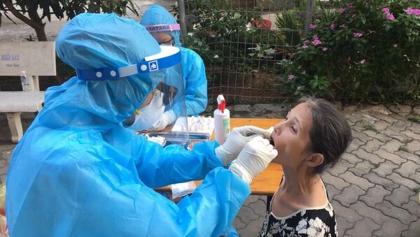Nhân viên y tế lấy mẫu xét nghiệm tại khu dân cư. - Sputnik Việt Nam