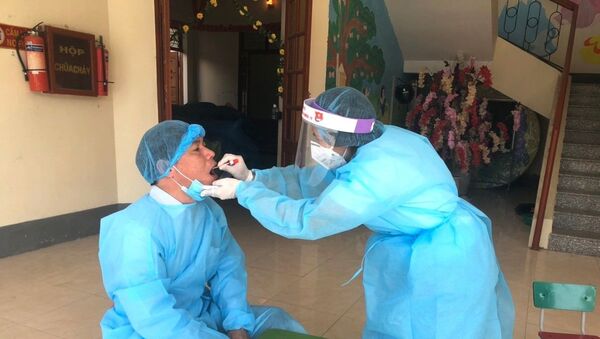 Lấy mẫu dịch họng cho chuyên gia y tế đến từ Bệnh viện Đa khoa tỉnh Hà Giang lên hỗ trợ điều trị cho bệnh nhân 268. - Sputnik Việt Nam