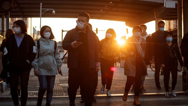 Người qua đường đeo mặt nạ bảo vệ trên một trong những con phố của Bắc Kinh, Trung Quốc - Sputnik Việt Nam