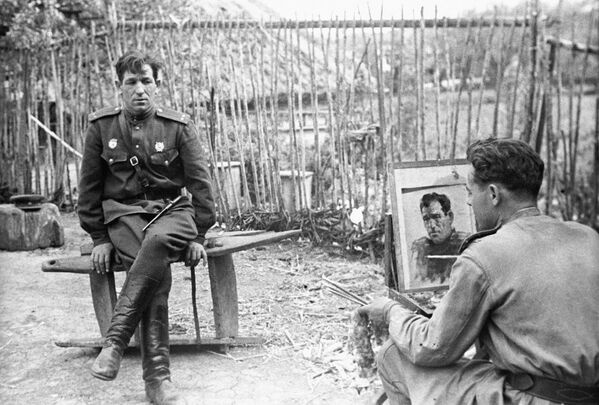 Nghệ sĩ làm việc tại xưởng vẽ của các nghệ sĩ quân đội Nikolai Sokolov đang sáng tác bức chân dung Trung úy N. Bryskin, 1944 - Sputnik Việt Nam