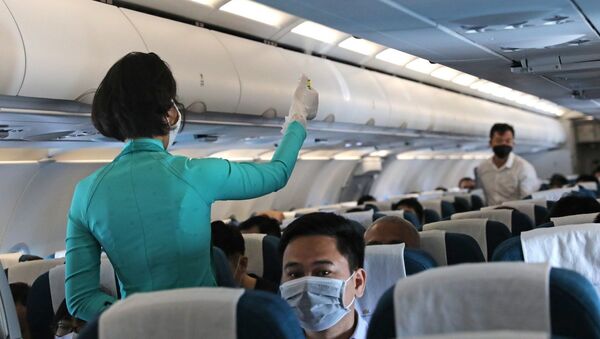 Nhân viên Vietnam Airlines xịt khử khuẩn trước chuyến bay. - Sputnik Việt Nam