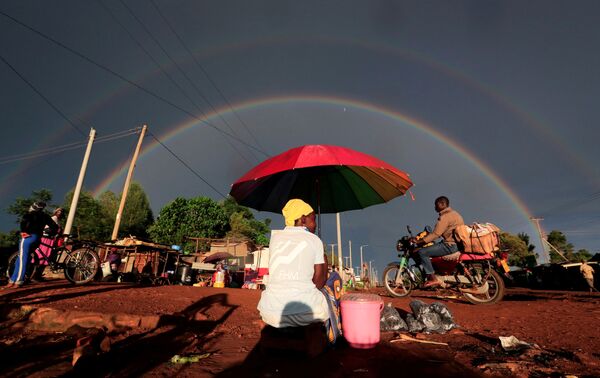 Cầu vồng đôi và người phụ nữ bán đồ ăn nhẹ trên con đường ở huyện Xi'a, Kenya - Sputnik Việt Nam