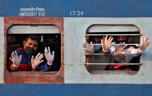 Hành khách vẫy tay từ cửa sổ xe lửa ở Ấn Độ - Sputnik Việt Nam
