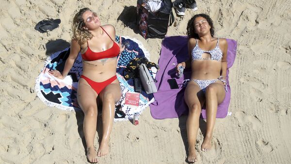 Hai cô gái tắm nắng trên bãi biển Callercoats, Anh - Sputnik Việt Nam