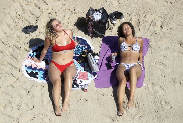 Hai cô gái tắm nắng trên bãi biển Callercoats, Anh - Sputnik Việt Nam