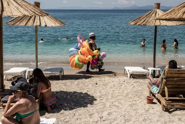Khách du lịch và người bán đồ chơi trên bãi biển thành phố Alimos ở ngoại ô Athens - Sputnik Việt Nam