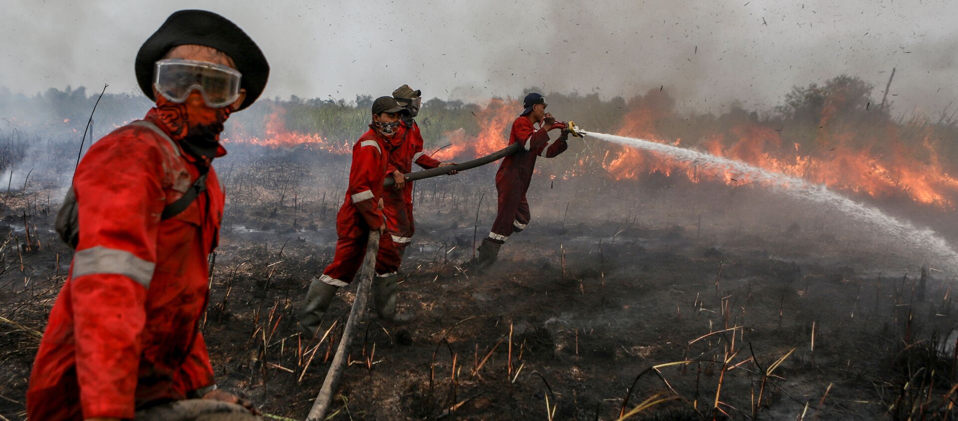 Lính cứu hỏa dập tắt đám cháy trên cánh đồng ở hạt Ogan-Ilir ở Nam Sumatra, Indonesia - Sputnik Việt Nam, 1920, 29.05.2020