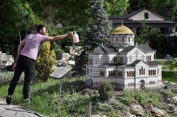 Người đàn ông đứng bên mô hình Nhà thờ Vladimir ở Khersones tại công viên Tiểu Crưm trong lòng bàn tay, ở thành phố Bakhchisarai - Sputnik Việt Nam