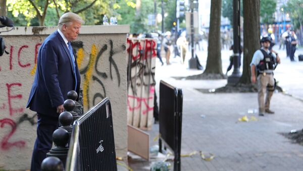 Tổng thống Mỹ Donald Trump đi ngang qua một tòa nhà được vẽ nguệch ngoạc graffiti của những người biểu tình ở Công viên Lafayette, đối diện Nhà Trắng - Sputnik Việt Nam