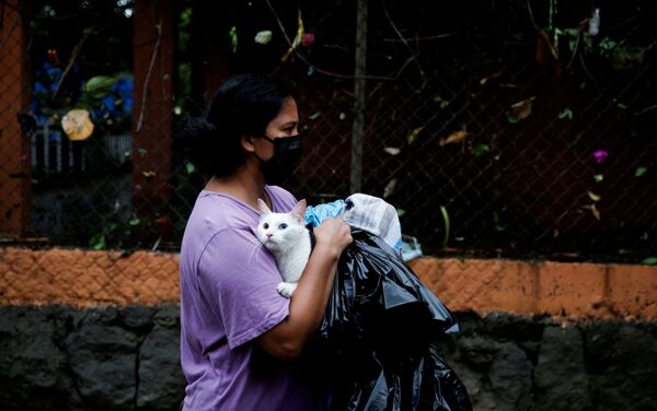 Một người phụ nữ đeo khẩu trang với một con mèo trong trận lụt do cơn bão nhiệt đới Amanda ở Ilopango, Salvador - Sputnik Việt Nam