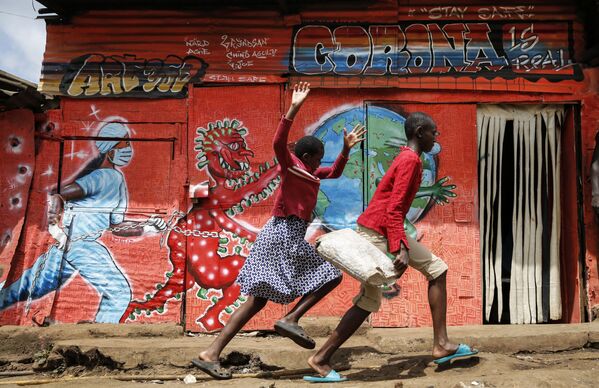 Trẻ em chạy trước tranh tường graffiti về coronavirus  trong khu ổ chuột Kibera ở Nairobi, Kenya - Sputnik Việt Nam