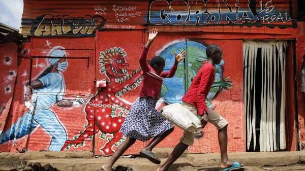Trẻ em chạy trước tranh tường graffiti về coronavirus trong khu ổ chuột Kibera ở Nairobi, Kenya - Sputnik Việt Nam