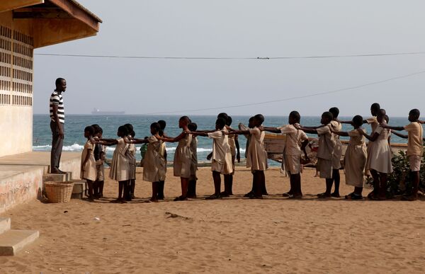 Học sinh xếp hàng trong sân trường, bị hư hại do bão và xói mòn bờ biển, ở Bagid, Togo - Sputnik Việt Nam