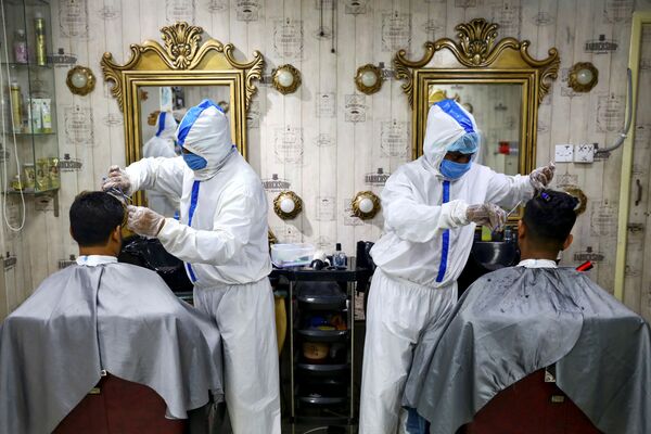 Thợ cắt tóc mặc đồ bảo hộ ở tiệm làm tóc tại Dhaka, Bangladesh - Sputnik Việt Nam